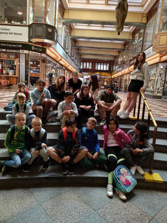 děti z DD sedí na schodech v muzeu v Praze.jpg